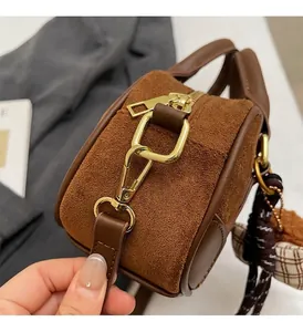 Detail of vintage brown bowling bag featuring premium gold hardware and suede texture