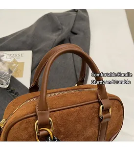 Detail of sturdy brown suede handbag handle with gold zipper and vintage D-ring