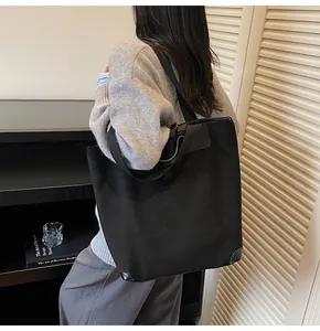 Detail of black corduroy tote bag showing reinforced corners and woven shoulder strap