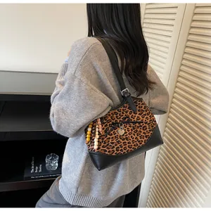 Close-up of leopard print tote bag with heart charm, bow detail and colorful bead tassel