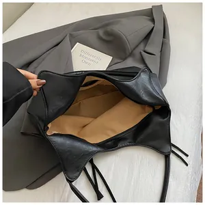 Vue de dessus d'un grand sac cabas en cuir noir avec doublure marron et zip