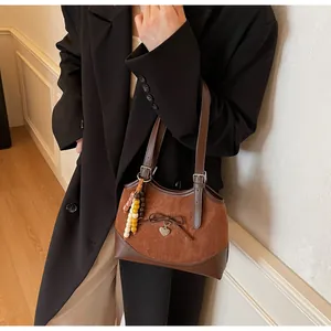 Detail of a brown leopard tote bag featuring a leather bow and vintage tassel charms