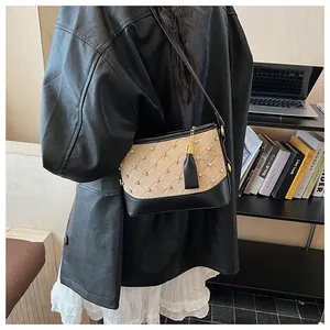 Détail du sac seau beige givré avec coutures en losange et accents de cristaux