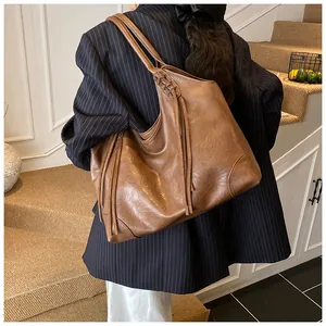 Détails du sac cabas en cuir marron avec franges et bandoulière tressée élégante