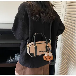 Detail of retro bowling bag in khaki brown suede with adjustable strap and cute dog charm