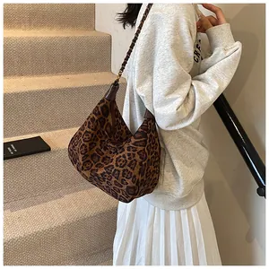 Detail of hobo bag with leopard print fabric and metal chain leather woven shoulder strap