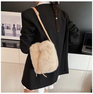 Detail of beige plush bucket bag showing fluffy faux fur texture and leather shoulder strap