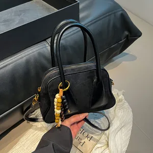 Minimalist black leather boston handbag with colorful wooden bead charm and shoulder strap