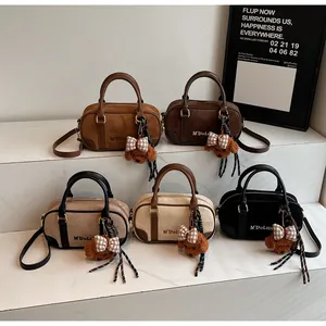 Detailed view of suede bowling bags in five colors with cute teddy bear pendants