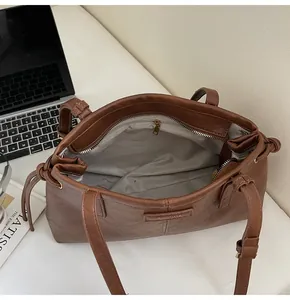 Detailed interior of a brown tote bag showing spacious lining and secure zipper pocket