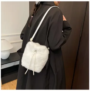 Detail of white faux fur bucket bag with drawstring and silver metal hardware accents