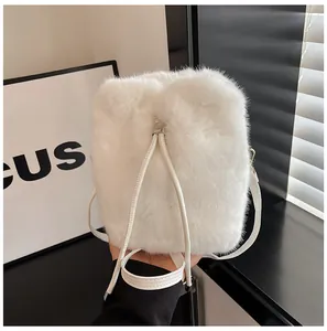 Detail of white faux fur bucket bag featuring gold hardware and soft drawstring closure