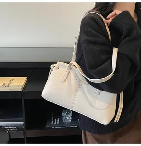 Detail of cream white leather shoulder bag with ZHONKA plate and decorative tassels