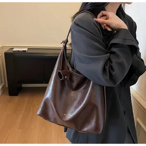 Detailed view of deep brown soft faux leather tote bag with elegant gold lettering