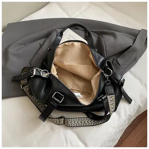 Detailed top view of large black tote bag showing beige lining and woven pattern strap