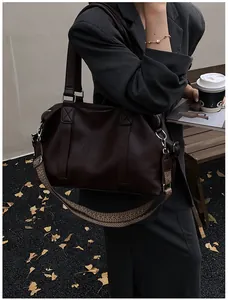 Detail of dark brown leather tote bag with stylish geometric pattern woven shoulder strap