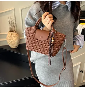 Detail der dunkelbraunen geflochtenen Ledertasche mit Faltenstruktur und Holzperlen-Anhänger