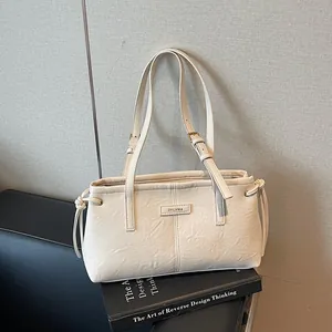 Minimalist beige leather shoulder bag with adjustable straps and soft pleated texture