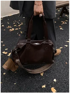 Detail of vintage brown tote with textured leather and wide colorful jacquard shoulder strap