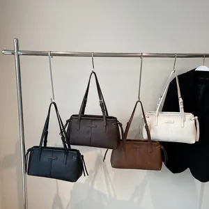 Retro faux leather shoulder bags in four colors hanging on a modern metal display rack