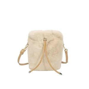 Plush cream bucket bag with drawstring closure and gold chain strap in minimalist style