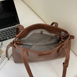 Brown leather tote bag with spacious interior and adjustable strap for commuting