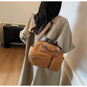 Vue détaillée d'un sac bandoulière marron à poches avec une large sangle tissée réglable