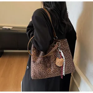 Détail du sac cabas léopard en toile avec bandoulière marron et charm ours mignon