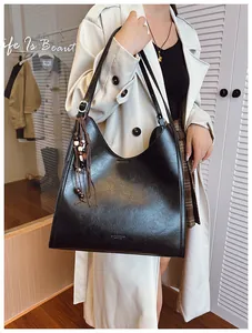 Détail du grand sac cabas en cuir PU noir avec texture vintage et pendentif perlé