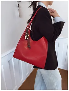 Détail du grand sac cabas rouge en cuir avec pendentif ethnique et boucle en métal