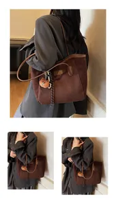 Großer brauner Shopper aus Wildleder mit Lederbesatz und Plüschbär-Anhänger im Detail