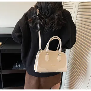 Chic beige leather handbag worn cross-body by a model showing size and styling
