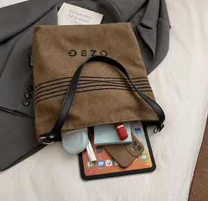 Detailansicht der Innenkapazität der braunen Canvas-Beuteltasche mit iPad und Büchern