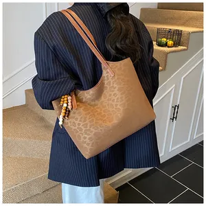 Détail du sac cabas vintage à imprimé léopard avec breloque élégante en perles de bois