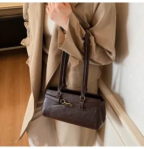 Detail of vintage dark brown shoulder bag with pleated leather texture and buckle strap