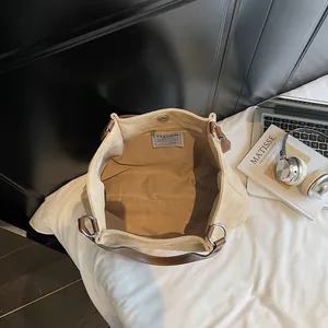 Minimalistische beige Tragetasche mit Ledergriffen und geräumigem Innenraum für Pendler