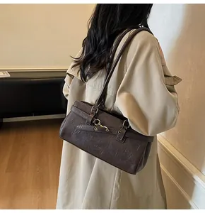 Detail of vintage dark brown faux leather underarm bag featuring metallic hook closure