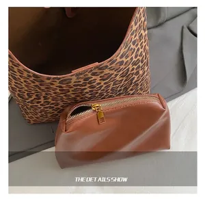 Detail van luipaardprint tote en kleine bruine tas met luxe goudkleurige metalen ritsdetails