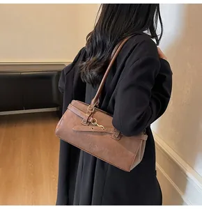 Macro view of vintage brown leather shoulder bag with metallic buckle and retro strap