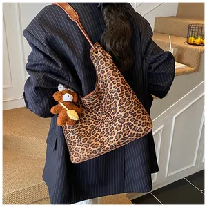 Detailed back view of leopard print tote bag with plush bear charm on shoulder