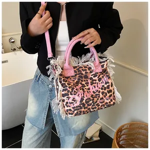 Detail of leopard print tote bag featuring white fringes and pink 'Fashion' lettering