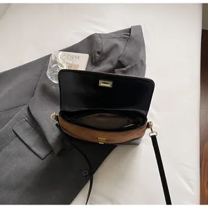 Dettaglio della borsa a tracolla in pelle scamosciata marrone e pelle nera con fibbia