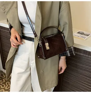 Detail of diamond-quilted brown suede shoulder bag with elegant gold metal twist-lock