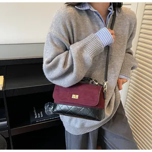 Dettaglio della borsa bicolore in pelle scamosciata bordeaux e pelle trapuntata nera con chiusura