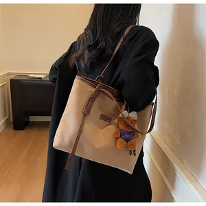 Detailansicht der großen braunen Wildleder-Tote-Bag mit Lederbesatz und Bärenanhänger