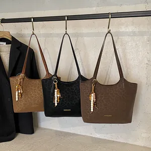 Trois sacs cabas vintage en cuir ciré avec motifs léopard et pompons perlés