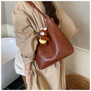 Brown faux leather tote bag detail with a cute plush bear charm for a casual look