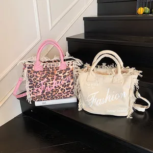 Leopard print canvas tote bag with pink tassel details and detachable shoulder strap