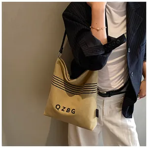 Detailed close-up of khaki canvas bucket bag with black stripes and QZBG print