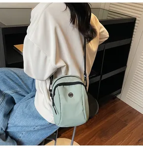 Detailed side view of mint green mini crossbody bag on model with black shoulder strap